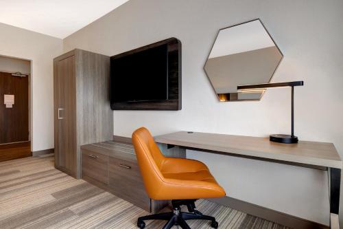 an office with a desk and a chair and a television at Holiday Inn Express & Suites - Glendale Downtown in Glendale