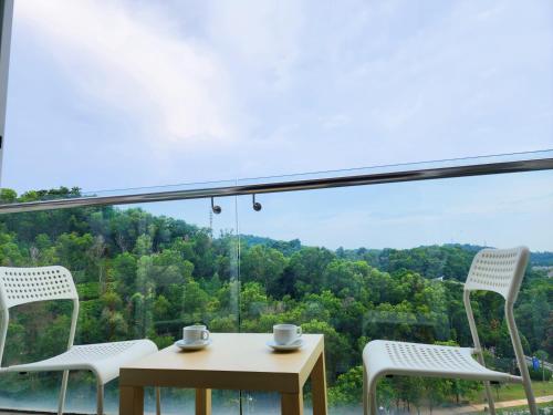 a table and chairs with a view of the forest at Dwiputra Presint 15 at Putrajaya Blissful Suite in Putrajaya