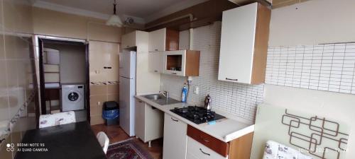 a small kitchen with white cabinets and a sink at Kule Apart in Trabzon
