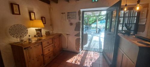 una cocina con una puerta que conduce a un patio en Logis Hôtel Les Vieilles Granges, en Granges-Les-Beaumont