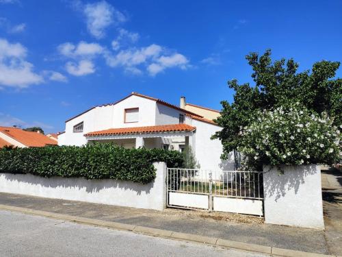 a white house with a white fence and flowers at Maison familiale près de la mer in Argelès-sur-Mer