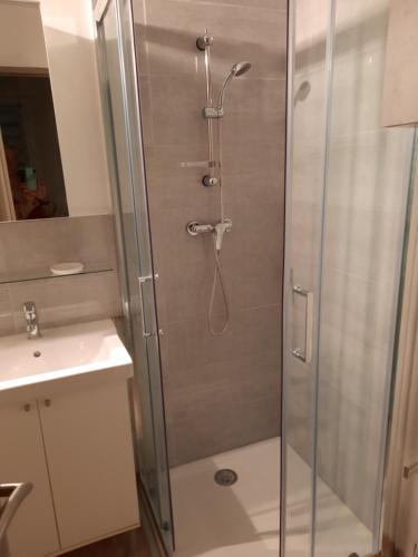 une douche avec une porte vitrée dans une salle de bain dans l'établissement LES LAVANDES, au Thoronet