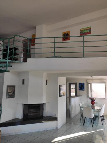 - un salon avec un escalier et une table avec des chaises dans l'établissement Maison familiale près de la mer, à Argelès-sur-Mer