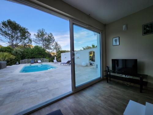 - un salon avec des portes coulissantes en verre et une piscine dans l'établissement LES LAVANDES, au Thoronet