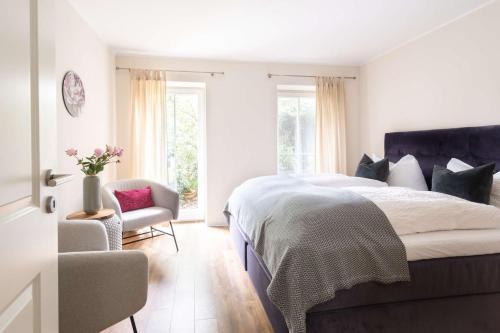 a bedroom with a large bed and a chair at Hofgut Mollberg in Wiefelstede