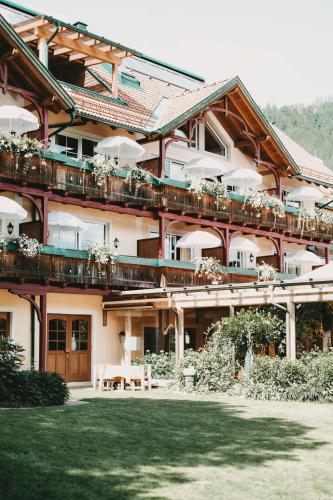 un gran edificio con balcones y una mesa en un patio en Hotel Rosenhof Murau, en Murau
