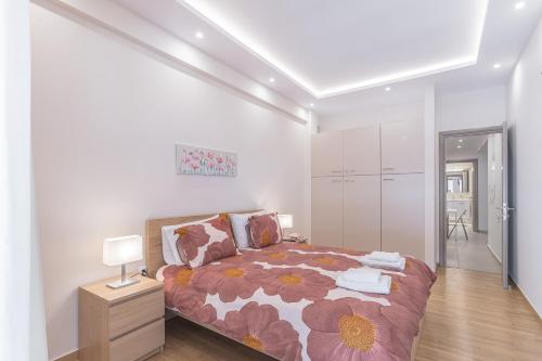 a bedroom with a bed with a flower patterned blanket at Amazing apartment near metro Station! in Athens