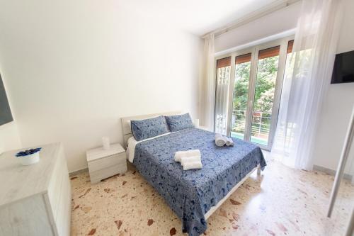 una camera con un letto blu e una grande finestra di A CASA DI MARCO Salerno CENTRO a Salerno