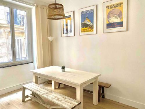 une table et un banc dans une pièce avec des affiches dans l'établissement Charmant Appartement Plein Centre, à Marseille