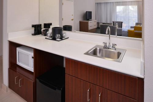 a kitchen with a sink and a microwave at Courtyard by Marriott Milwaukee North/Brown Deer in Brown Deer