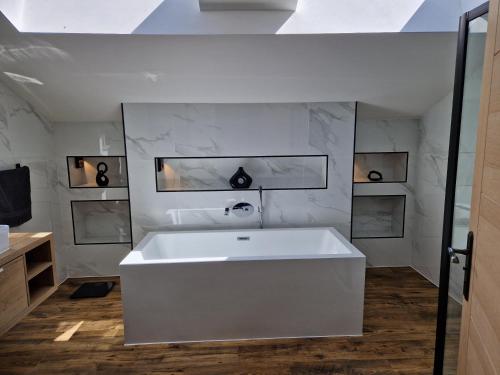 a bathroom with a white tub and a sink at Brand New Barn Retreat in Bedford