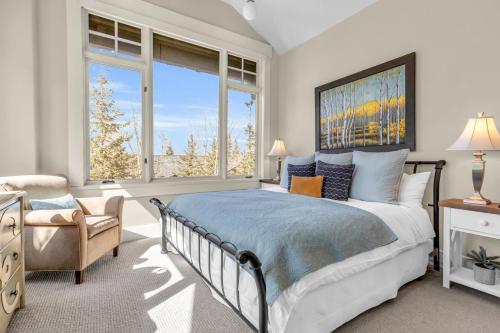 a bedroom with a bed and a chair and windows at West Red Pine Oasis in Park City