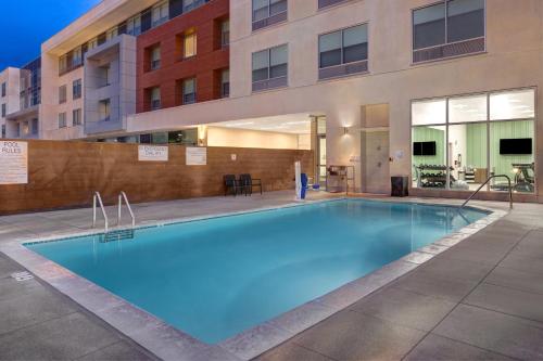 a large blue swimming pool in front of a building at Holiday Inn Express & Suites - Glendale Downtown in Glendale