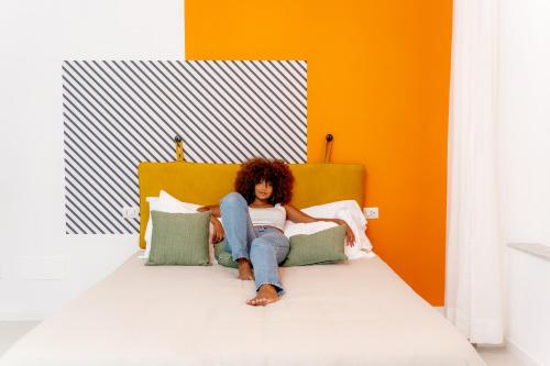 a woman sitting on top of a bed at Starguest Duomo in Naples