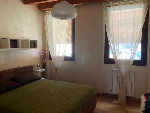 een slaapkamer met een groen bed en 2 ramen bij Accogliente appartamento in cascina lombarda in Segrate