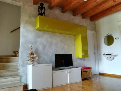 een woonkamer met een tv aan de muur bij Accogliente appartamento in cascina lombarda in Segrate