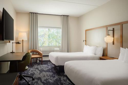 a hotel room with two beds and a desk and a window at Fairfield by Marriott Inn & Suites Knoxville Northwest in Knoxville