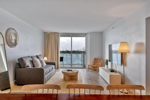 un soggiorno con divano e tavolo di 1100 West South Beach Luxe Miami Condos by Joe Semary a Miami Beach