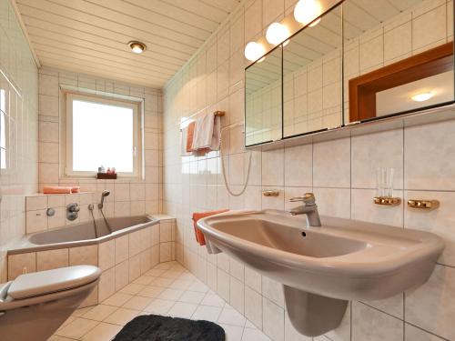 a bathroom with a sink and a tub and a mirror at Haus Meyer in Filzmoos