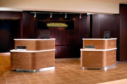 a lobby with wooden counters and a potted plant on the wall at Courtyard by Marriott Atlanta Duluth/ Gwinnett Place in Duluth