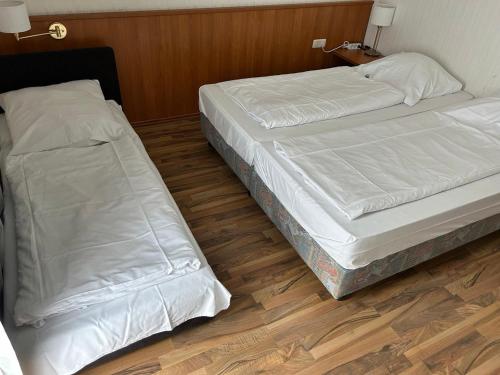 two beds sitting next to each other in a room at West End Apartments in Frankfurt/Main
