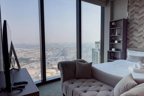 a bedroom with a bed and a couch in front of a window at Luxury1BR at The Address Residences in JBR in Dubai