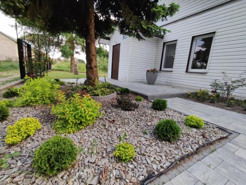 a garden in front of a house at Tonkielek - Domek z Jacuzzi Nad Rzeką Bug in Tonkiele
