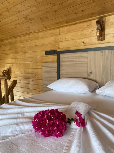 a bedroom with a bed with pink flowers on it at Cebel Tiny House&Bungalovs in Kemer