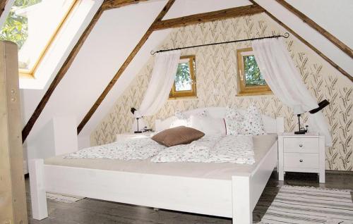 a bedroom with a white bed and two windows at Nussbaumerhof 