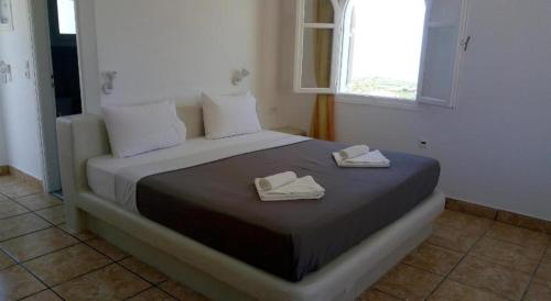 1 dormitorio con 1 cama con 2 toallas en fira blue horizon, en Fira