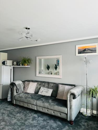 a living room with a gray couch in a room at The Annex in Southend-on-Sea