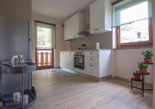 uma cozinha com armários brancos e um fogão em La casa delle farfalle - CIR VDA SARRE 0001 em Aosta