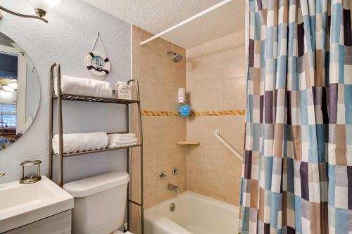 a bathroom with a tub and a sink and a shower at Less Than Half-Mi to St Pete Beach Condo with Pool! in St Pete Beach