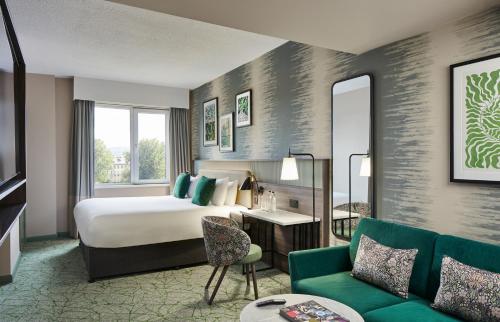 a hotel room with a bed and a couch at Leonardo Royal Hotel Glasgow in Glasgow