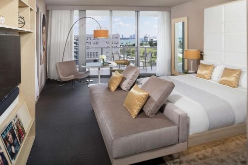 a hotel room with a large bed and a couch at The Gabriel Miami Downtown, Curio Collection by Hilton in Miami