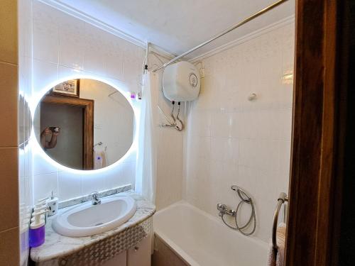 a bathroom with a sink and a mirror and a tub at 3 bedroom flat with wifi in Valencia