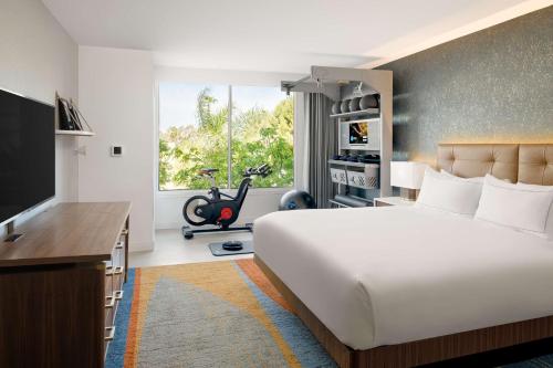 a bedroom with a bed and a desk and a tv at Hilton Los Angeles-Culver City, CA in Los Angeles