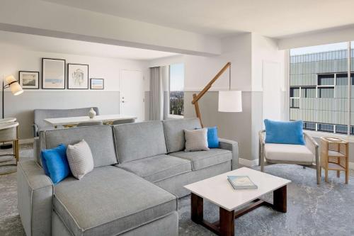 a living room with a gray couch and blue pillows at Hilton Los Angeles-Culver City, CA in Los Angeles