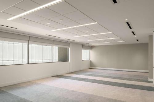 an empty room with white walls and windows at Hilton Los Angeles-Culver City, CA in Los Angeles