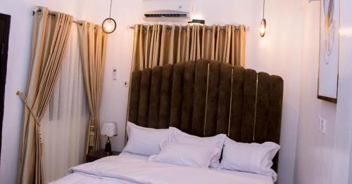 a bed with a large wooden headboard in a bedroom at JEFA Deluxe Suites in Lagos