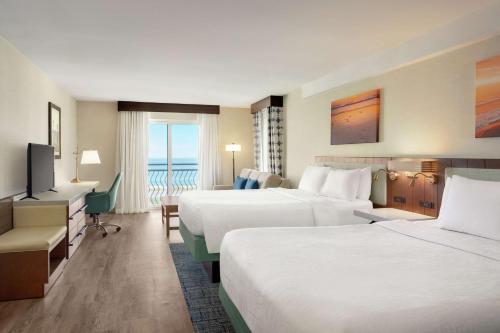 ein Hotelzimmer mit 2 Betten und einem TV in der Unterkunft Hilton Garden Inn Carlsbad Beach in Carlsbad