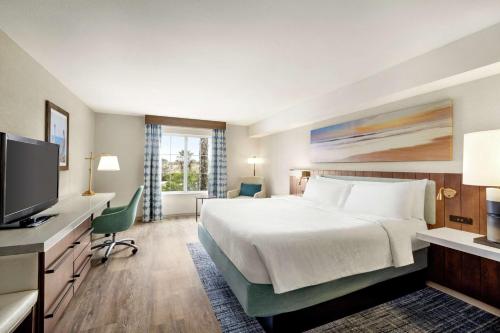 a hotel room with a bed and a flat screen tv at Hilton Garden Inn Carlsbad Beach in Carlsbad