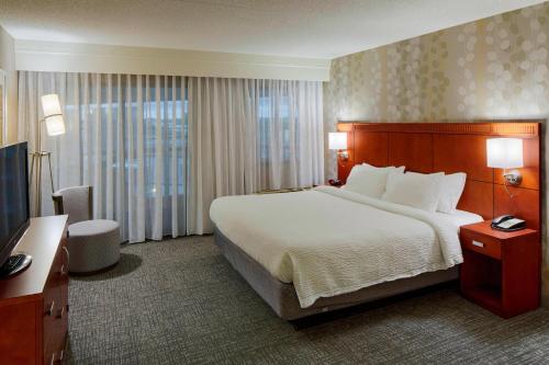 Pokój hotelowy z dużym łóżkiem i telewizorem w obiekcie Courtyard by Marriott Columbus West/Hilliard w mieście Columbus