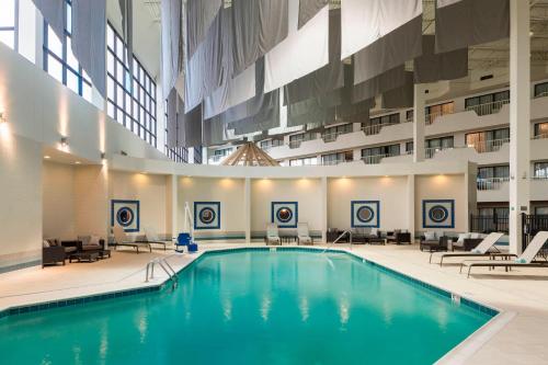 a large pool in a building with chairs and tables at Courtyard by Marriott Columbus West/Hilliard in Columbus