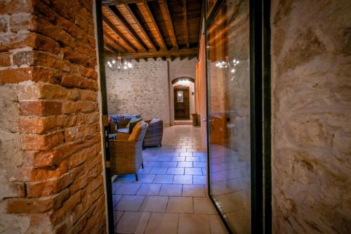 un couloir dans un bâtiment en pierre avec une porte en verre dans l'établissement La Maison du Garde, domaine de La Drelas, 6 couchages, pierre et bois,, à Chaumont-sur-Tharonne