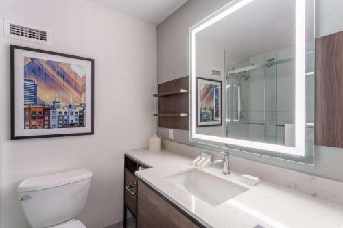 y baño con lavabo blanco y espejo. en Hilton Garden Inn San Francisco/Oakland Bay Bridge, en Emeryville
