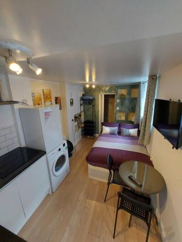 a small room with a bed and a small table at Quiet and cozy studio in Hendon