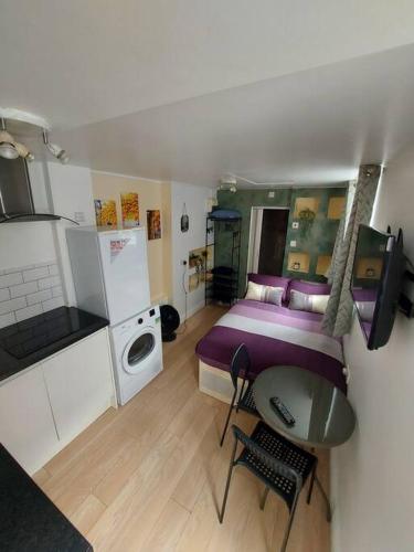 een slaapkamer met een bed en een tafel en een keuken bij Quiet and cozy studio in Hendon