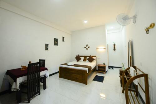 Dambulla Kings Inn في دامبولا: غرفة نوم بسرير في غرفة