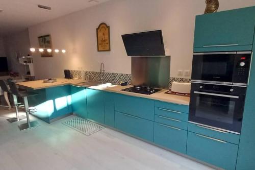 La cuisine est équipée de placards bleus et d'un four avec plaques de cuisson. dans l'établissement appartement centre ville avec terrasse, à Sanary-sur-Mer